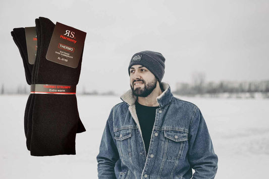 Jeune homme avec son blouson en jean col en fourure et son bonnet en laine sur la tête se promène l'hiver et sourit car il porte ses chaussettes chaudes avec des bouclettes aux pieds